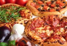 Three pizzas with various toppings and fresh ingredients.