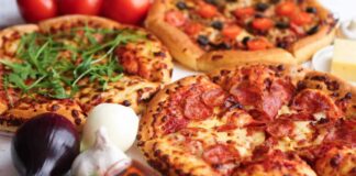 Three pizzas with various toppings and fresh ingredients.