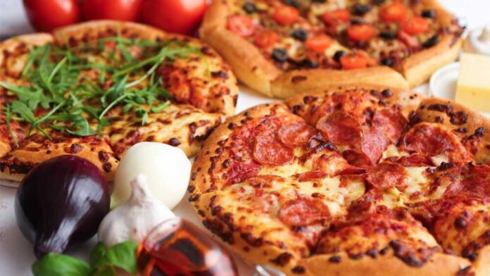shutterstock_2506660331.jpg featured image Three pizzas with various toppings and fresh ingredients.