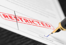 Document labeled restricted with pen signing signature line