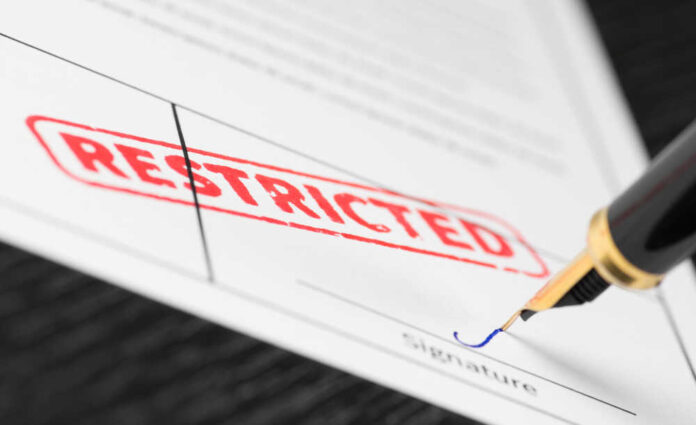Document labeled restricted with pen signing signature line