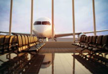 Airplane viewed from an empty airport waiting area.