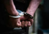 Close-up of hands in handcuffs behind back