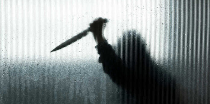 shutterstock_1494549677.jpg Silhouette of a man holding a knife