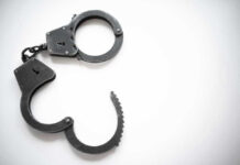 Open metal handcuffs on white background