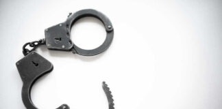 Open metal handcuffs on white background