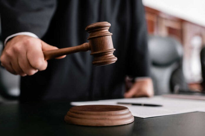 shutterstock_2121705137.jpg Judge holding gavel in courtroom