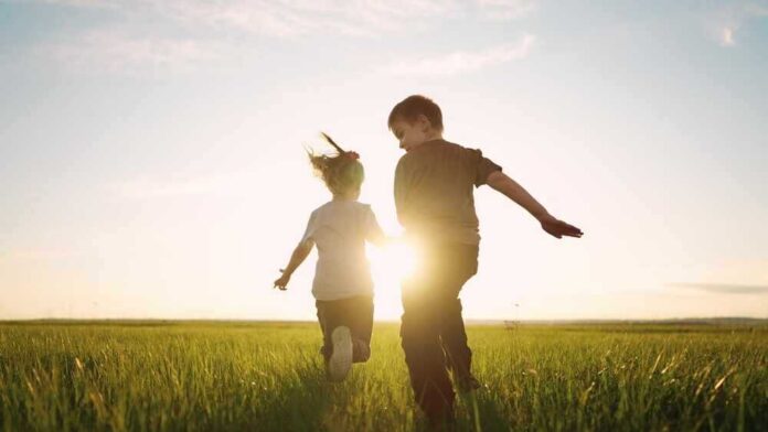 shutterstock_2173525569.jpg featured image Children running in a field at sunset.