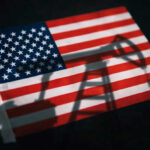 American flag with oil pump shadow overlay.