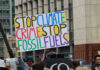 Protest sign reading Stop Climate Crime Stop Fossil Fuels