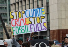 Protest sign reading Stop Climate Crime Stop Fossil Fuels
