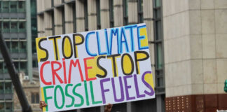 Protest sign reading Stop Climate Crime Stop Fossil Fuels