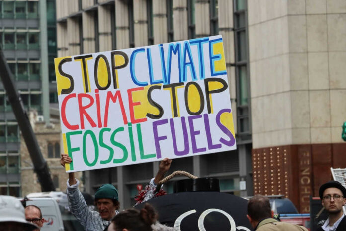 Protest sign reading Stop Climate Crime Stop Fossil Fuels