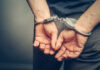 Person with handcuffs behind their back.
