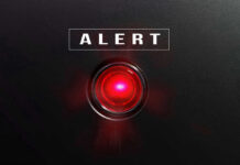Red alert light against black background text ALERT
