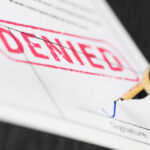 Denied stamp and pen signing document