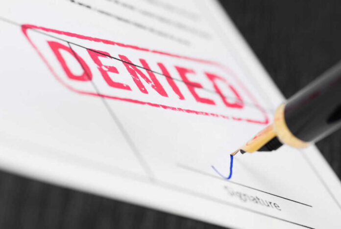 shutterstock_1058833358.jpg Denied stamp and pen signing document