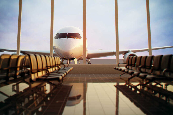 shutterstock_124713472.jpg Airplane viewed from an empty airport waiting area