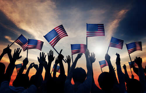 shutterstock_216220174.jpg Silhouetted crowd holding American flags against a sunset