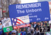 Pro-life marchers holding various anti-abortion signs