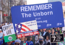 Pro-life marchers holding various anti-abortion signs