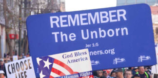 Pro-life marchers holding various anti-abortion signs