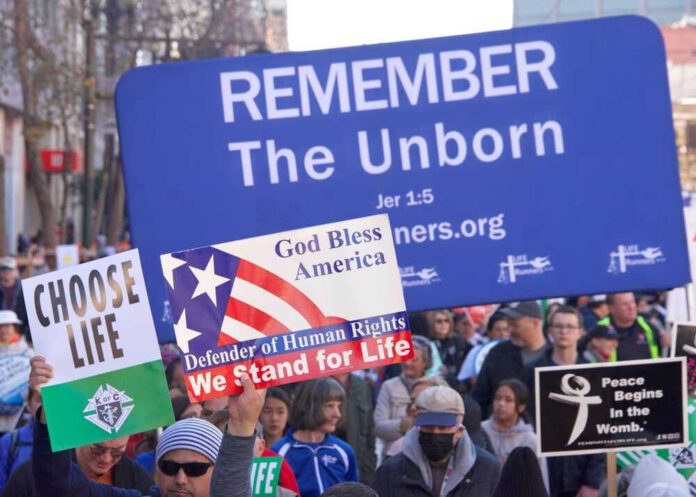 Pro-life marchers holding various anti-abortion signs