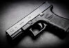 Black Glock 19 pistol on a dark surface
