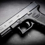 Black Glock 19 pistol on a dark surface