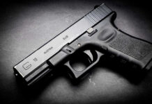 Black Glock 19 pistol on a dark surface
