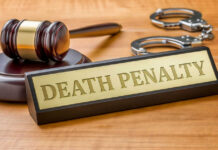 Gavel handcuffs and death penalty sign on table