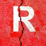 Cracked red wall with white letter R