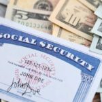 A social security card placed on top of various denominations of US currency