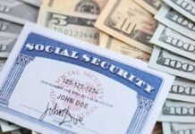 A social security card placed on top of various denominations of US currency