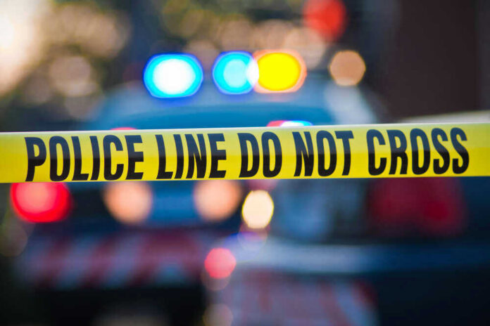 shutterstock_56280433.jpg Police tape and lights at crime scene