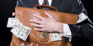 Person holding briefcase with money protruding from it