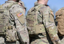Soldiers in camouflage uniforms with American flag patches