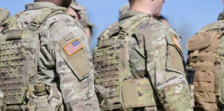 Soldiers in camouflage uniforms with American flag patches