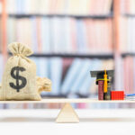 Money bag and books balanced on a seesaw