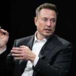 Musk Teams With Trump Czar Against Wikipedia Elon Musk in a suit talking.