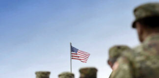 Soldiers in uniform with American flag in background