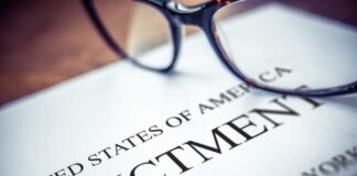 Close-up of an indictment document with glasses resting on it