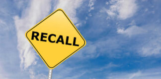 Yellow sign with RECALL text against blue sky