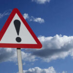 MYSTERY Object STRIKES Boeing at 36,000 Feet — Forced Landing Warning sign with exclamation mark against sky