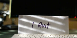Envelope reading I Quit behind keyboard.