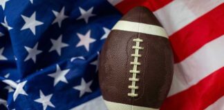 An American football resting on a background of the American flag