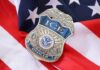 ICE officer badge resting on an American flag