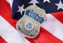 Massive ICE Raid Shakes Lib City Overnight ICE officer badge resting on an American flag