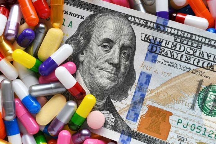 A hundred dollar bill surrounded by various colorful capsules and pills