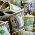 Rolled U.S. dollar bills in various denominations.